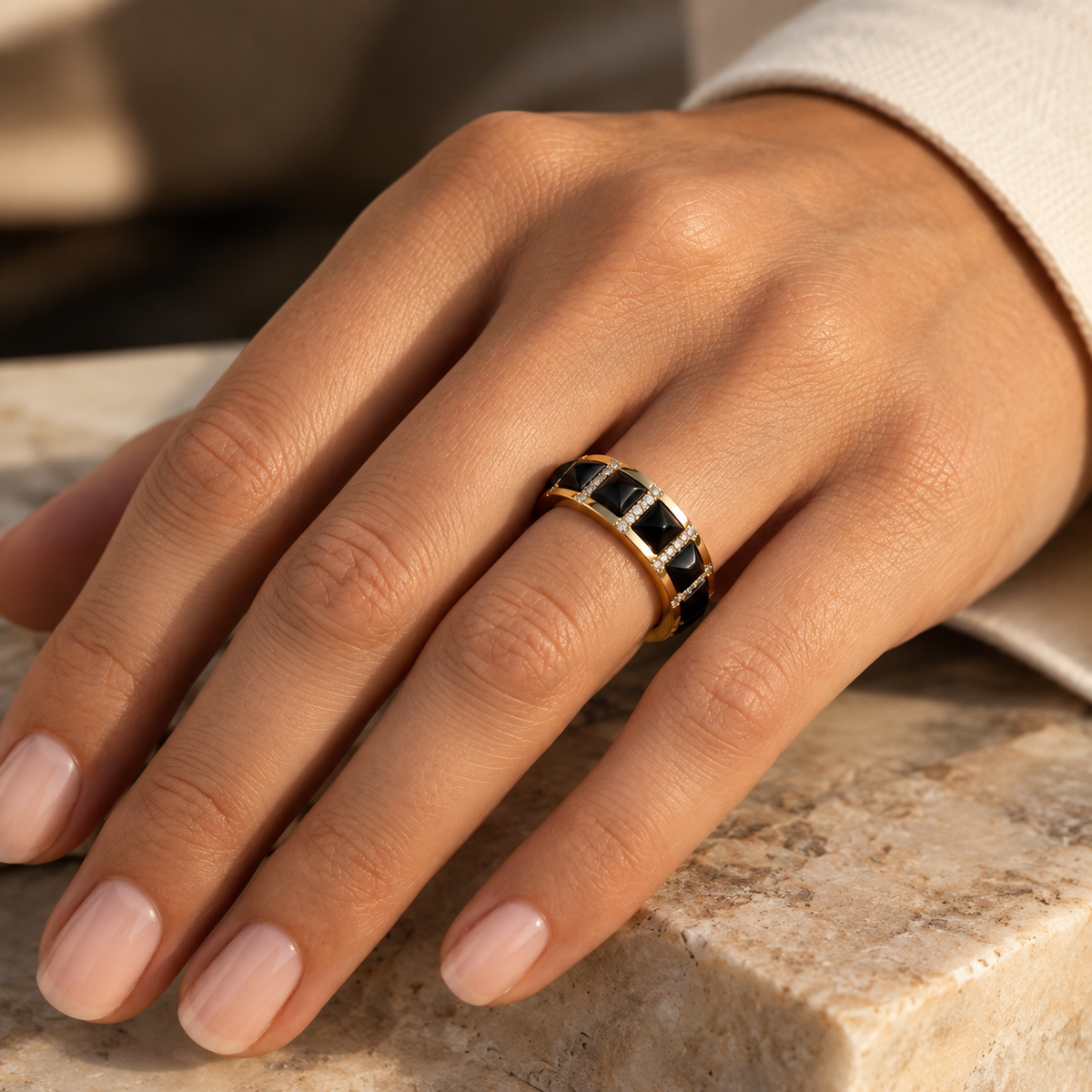 Bague Art Déco avec motif clou en onyx noir et diamants en or jaune 18 carats portée à l'annulaire d'une femme.