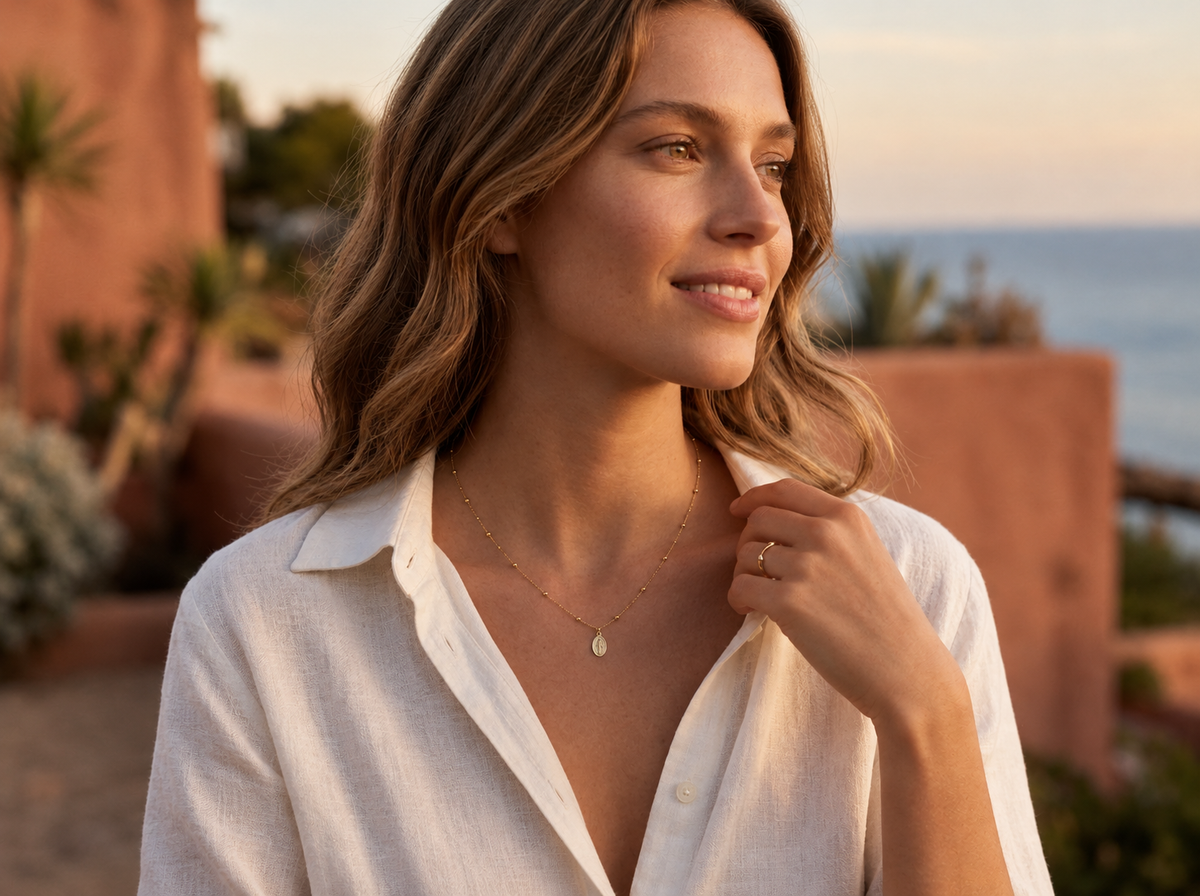 Collier religieux avec médaille de la Vierge en or 18 carats porté par une femme paisible au crépuscule.