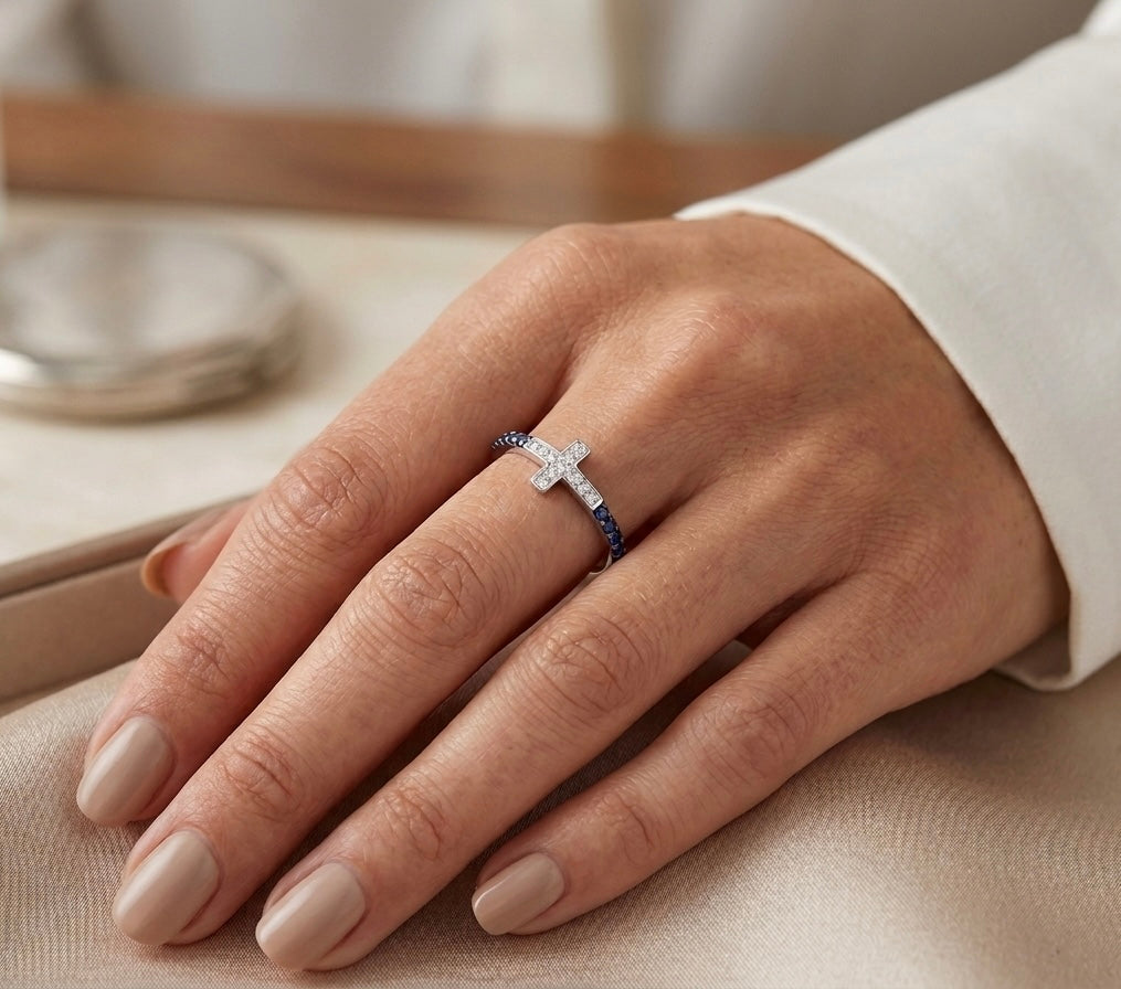 Bague de luxe avec motif croix en or blanc et pierres précieuses portée par une femme, style élégant.