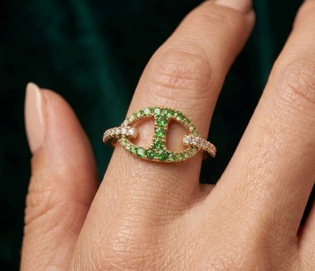 Bague maille marine en or jaune 18 carats, pavée de grenats verts et de diamants portée par une femme