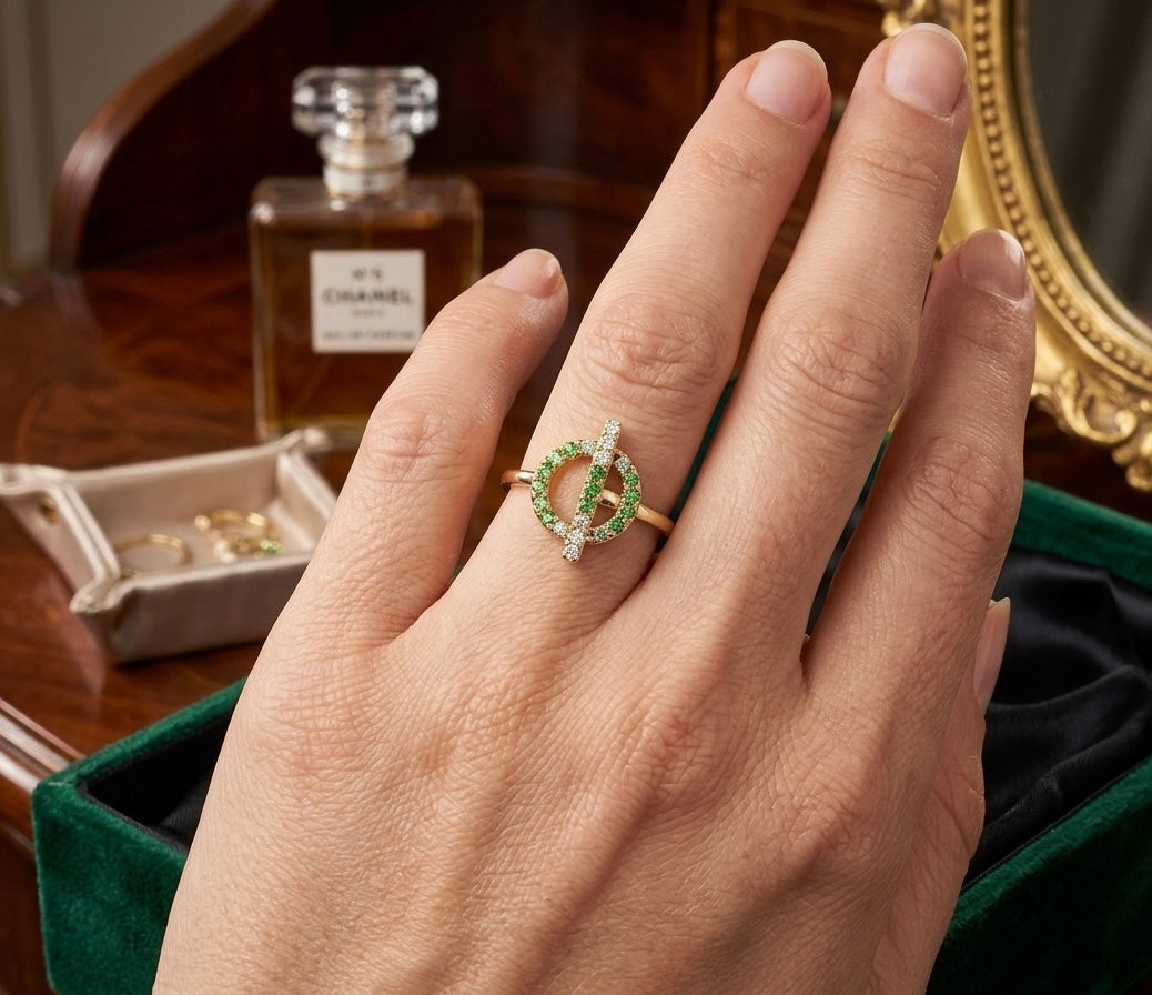 Bague Croisette en or jaune 18 carats avec cercle et barre, pavée de grenats verts et de diamants portée par une femme