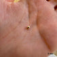 Petite perle en or 9k (375/1000) de 3 mm de diamètre au creux de la main