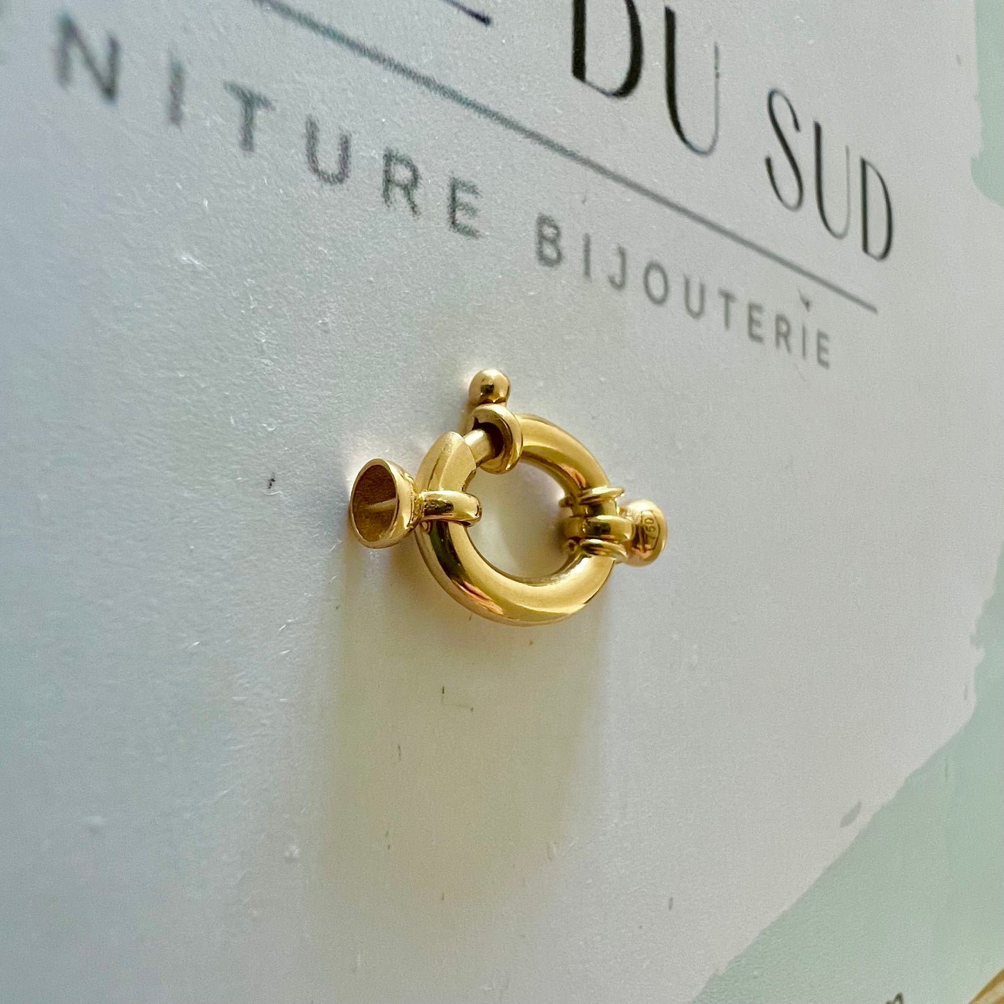 Gros plan sur un fermoir bouée ovale en or 750 millièmes, apprêt de haute qualité pour créateur de bijoux.