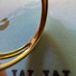 Gros plan du poinçon de garantie officiel 750 certifiant l'or jaune 18 carats gravé à l'intérieur de l'anneau de la bague ouverte.
