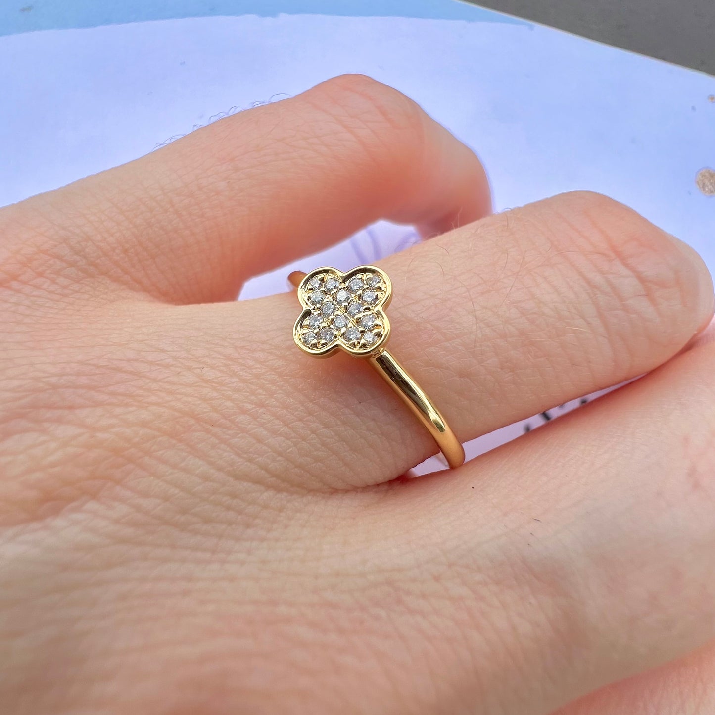 Vue de profil d'une bague trèfle en or 750 millièmes montrant le sertissage des diamants.