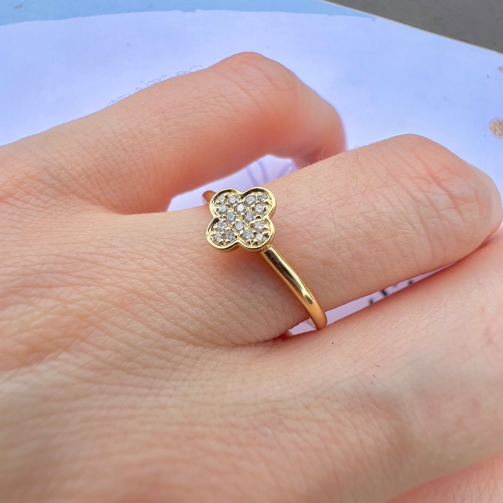 Vue de profil d'une bague trèfle en or 750 millièmes montrant le sertissage des diamants.