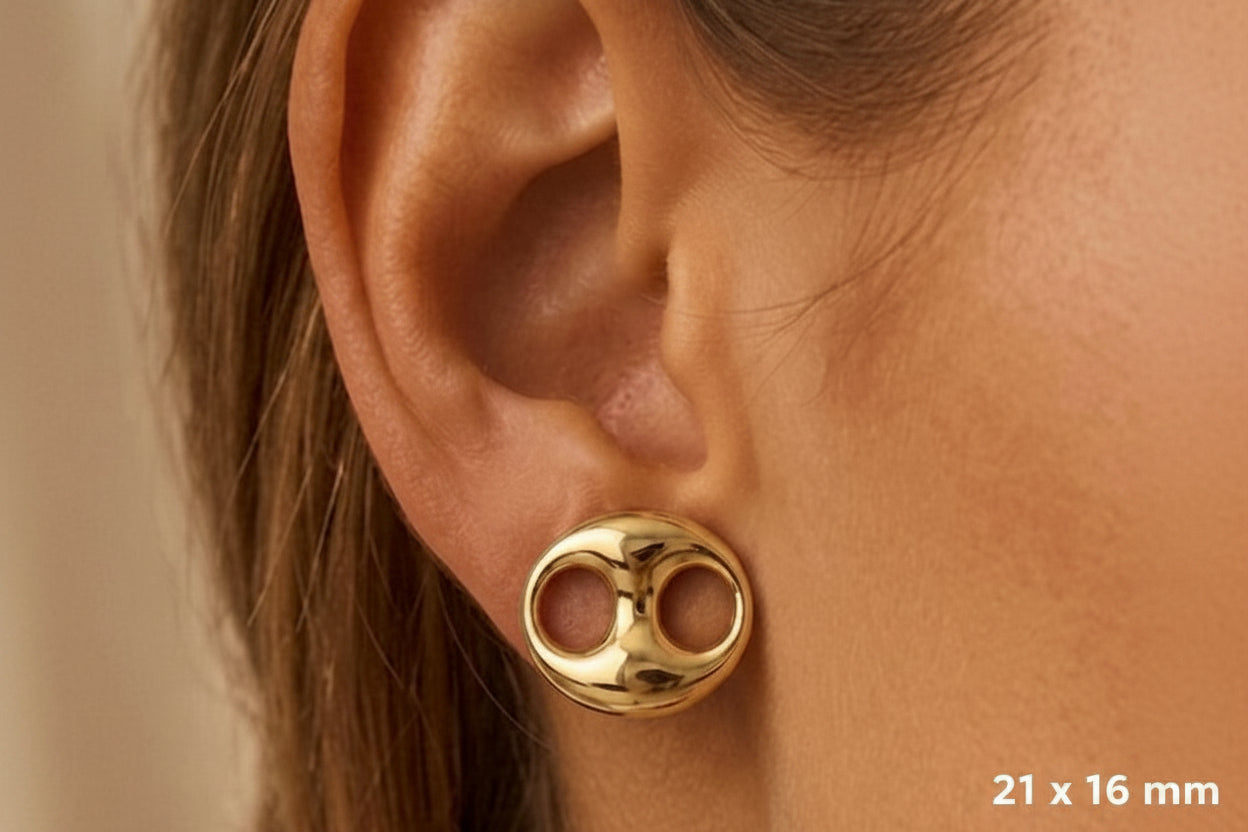 Gros plan sur une oreille de femme portant une puce d'oreille grain de café en or 18 carats en position horizontale, éclat poli miroir.
