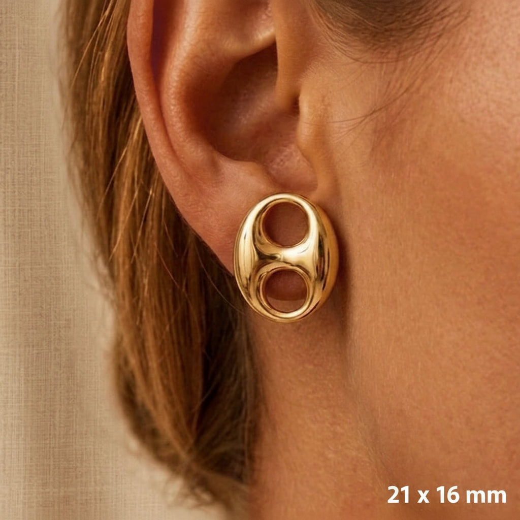 Gros plan sur une oreille de femme portant une puce d'oreille grain de café en or 18 carats en position verticale, éclat poli miroir.