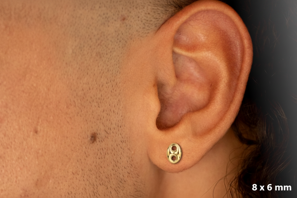 Boucle d'oreille grain de café en or 18 carats portée par un homme, style unisexe et moderne.