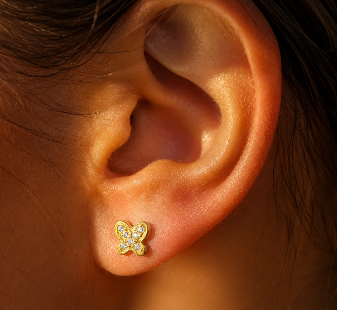 Puce d'oreille papillon en or jaune 18 carats portée au lobe d'une jeune fille avec fermoir à vis.