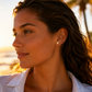 Boucles d'oreilles papillon en or 18 carats portées par une femme au soleil