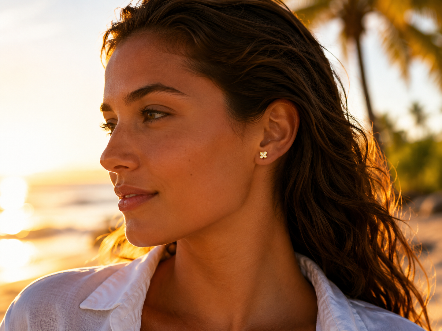 Boucles d'oreilles papillon en or 18 carats portées par une femme au soleil
