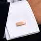Détail élégant d'un bouton de manchette en or rose 18 carats porté au poignet, un accessoire de luxe idéal pour un costume de marié.