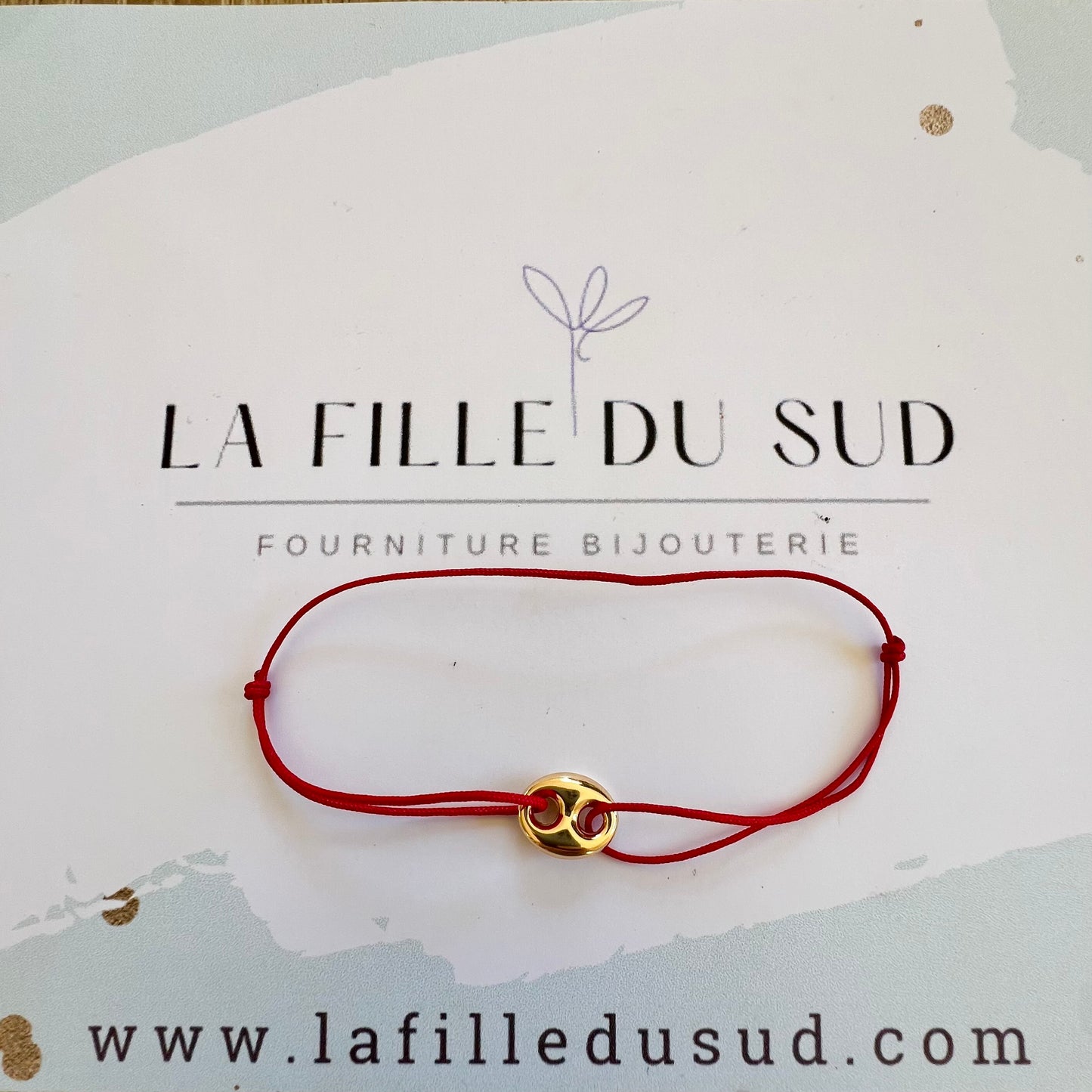 Bracelet cordon rouge porte-bonheur avec un graine de café en or 18 carats.