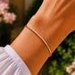 Poignet féminin orné du bracelet barrette en diamant et or rose 18 carats, mettant en valeur la douceur de l'alliage et l'éclat des pierres.
