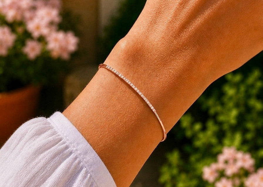 Poignet féminin orné du bracelet barrette en diamant et or rose 18 carats, mettant en valeur la douceur de l'alliage et l'éclat des pierres.