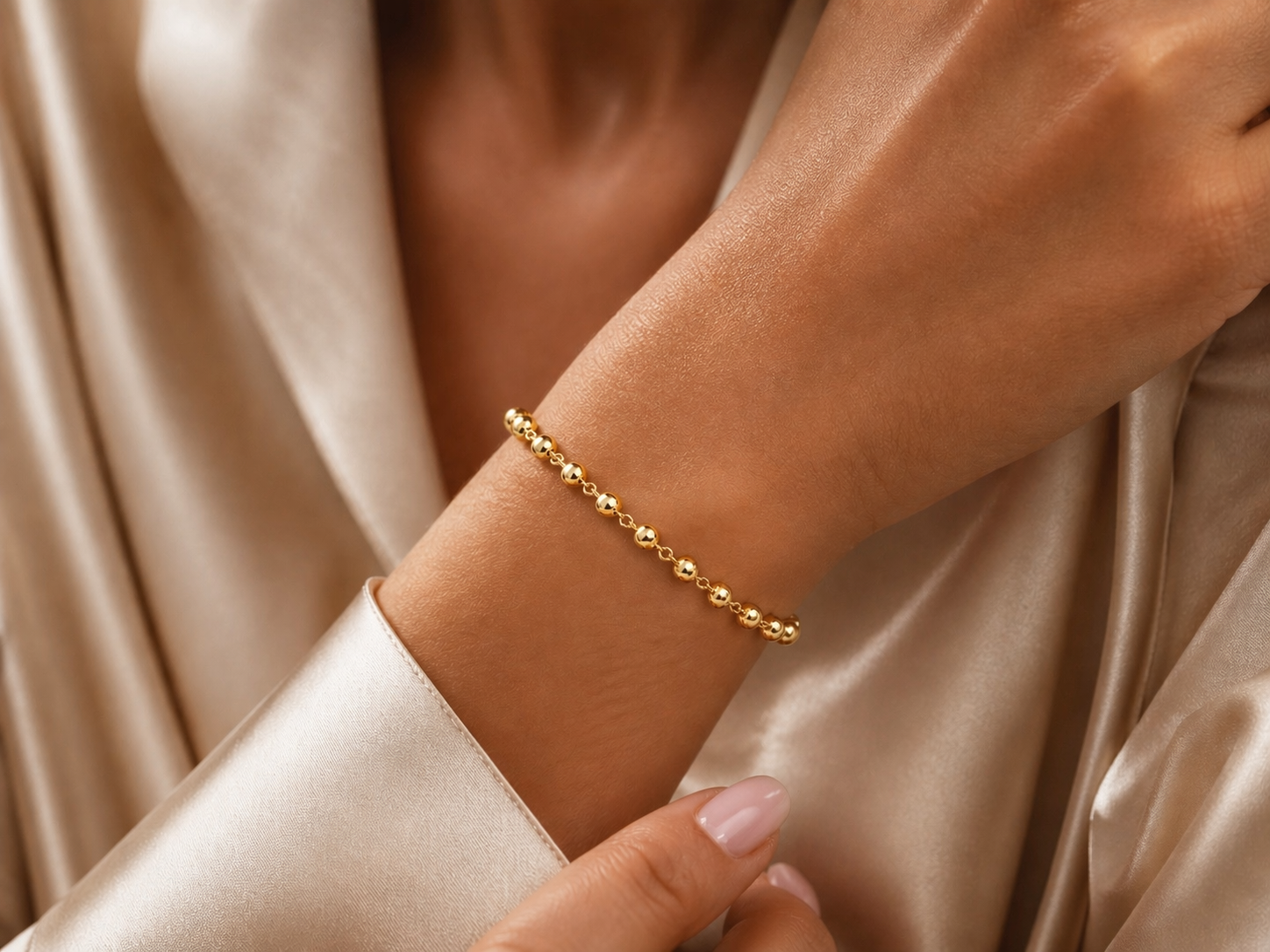 Gros plan d'un poignet de femme portant le bracelet marseillais en or 18 carats, bijou traditionnel et élégant.