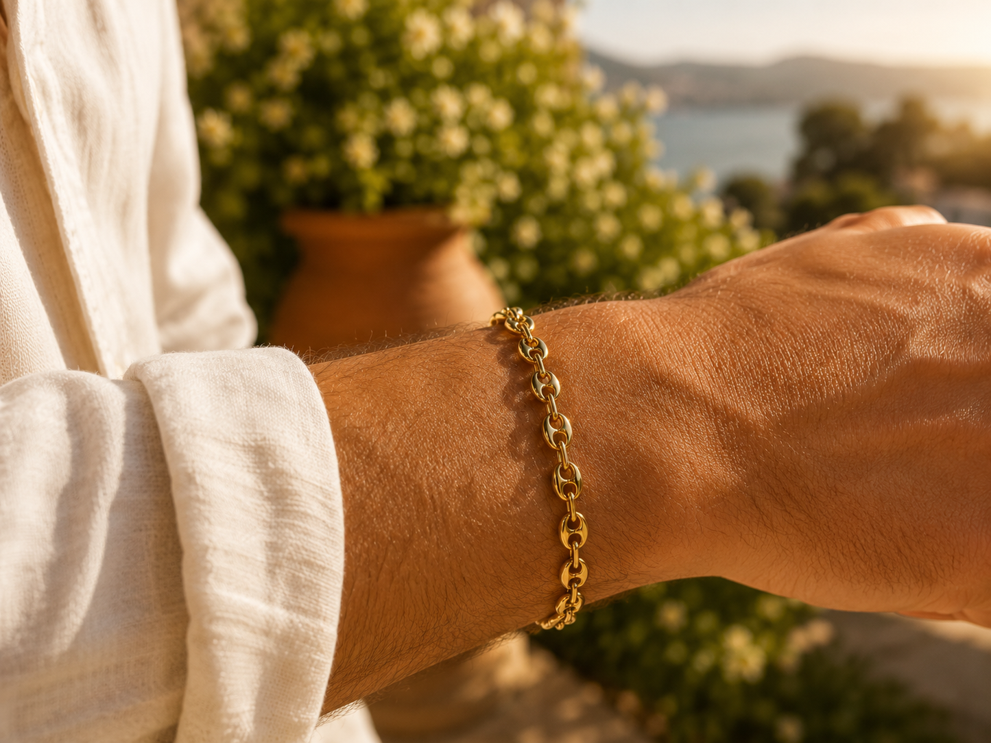 Poignet d'homme portant un bracelet en or jaune 18 carats maille grain de café, style luxe et masculin.