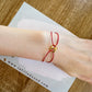 Bracelet cordon rouge porte-bonheur avec un graine de café en or 18 carats.