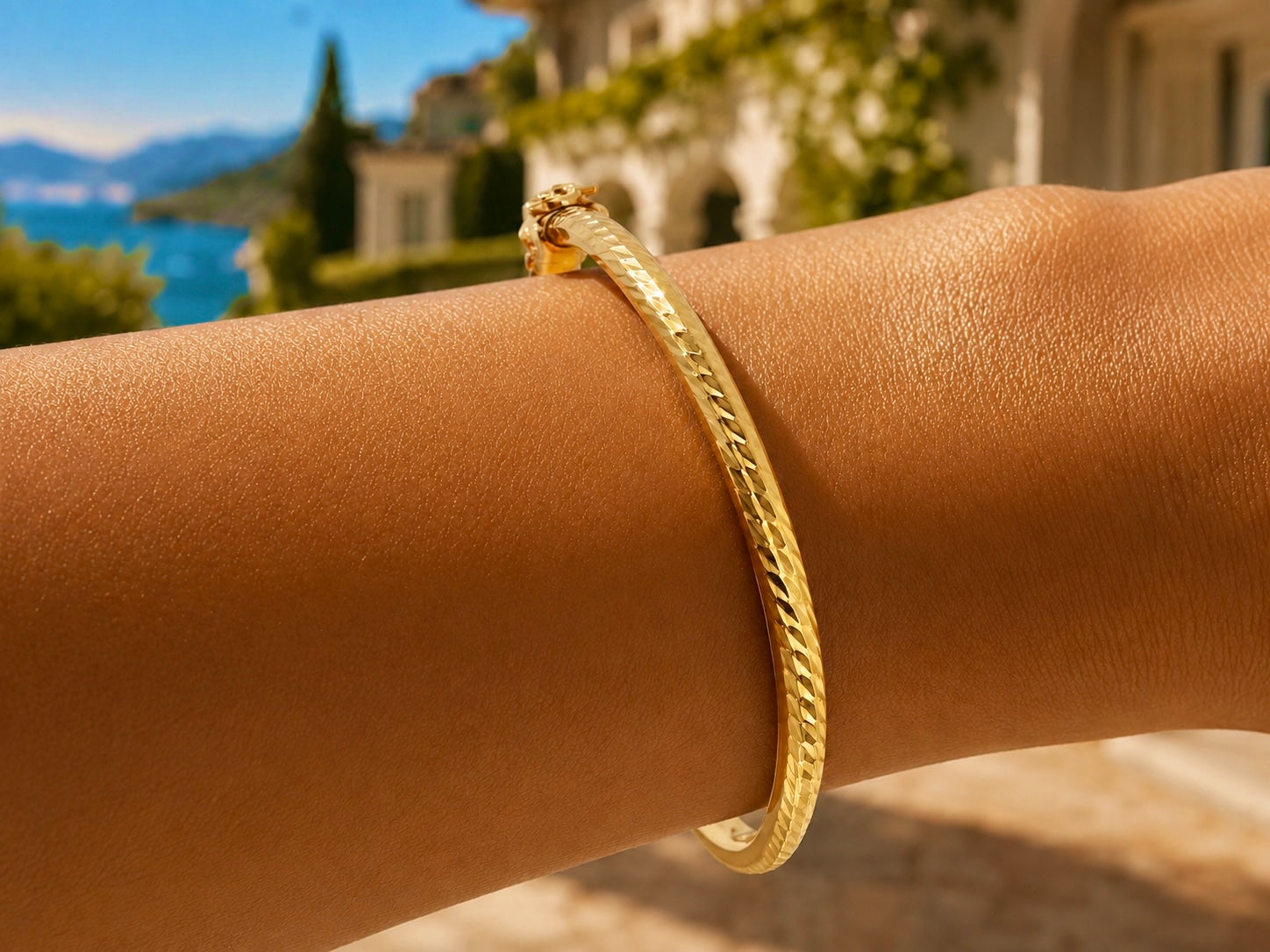 Gros plan sur le poignet d'une femme portant un bracelet jonc carré ciselé en or jaune 18 carats, éclat solaire et design géométrique.