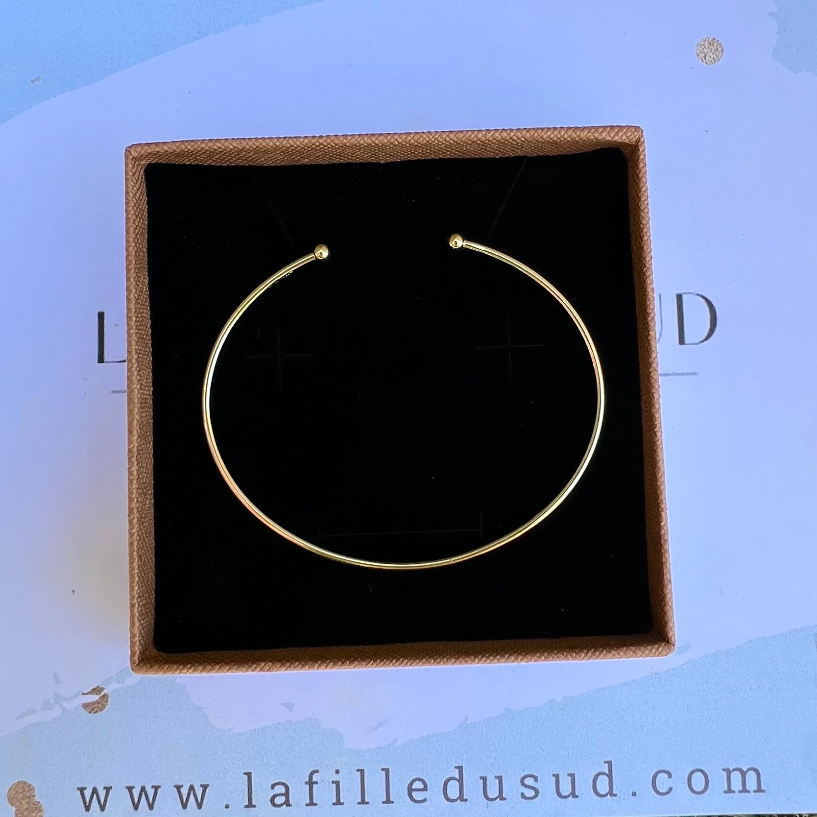 Bracelet jonc ouvert en or 18 carats massif présenté dans son écrin de luxe noir, idée cadeau joaillerie.