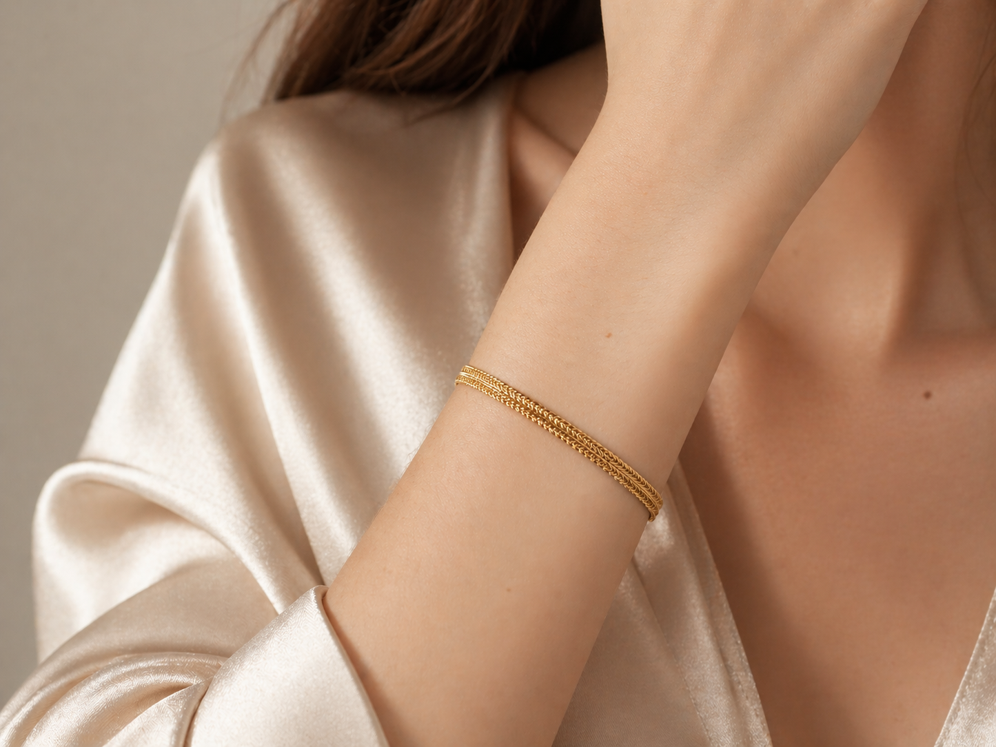 Gros plan sur un poignet de femme portant un bracelet maille palmier plate en or jaune 18 carats, design double palmier élégant et lumineux.