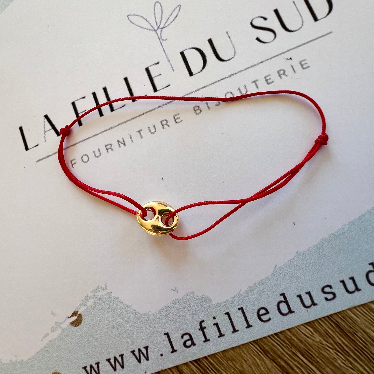 Bracelet cordon rouge porte-bonheur avec un graine de café en or 18 carats.