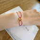 Bracelet cordon rouge porte-bonheur avec un graine de café en or 18 carats.