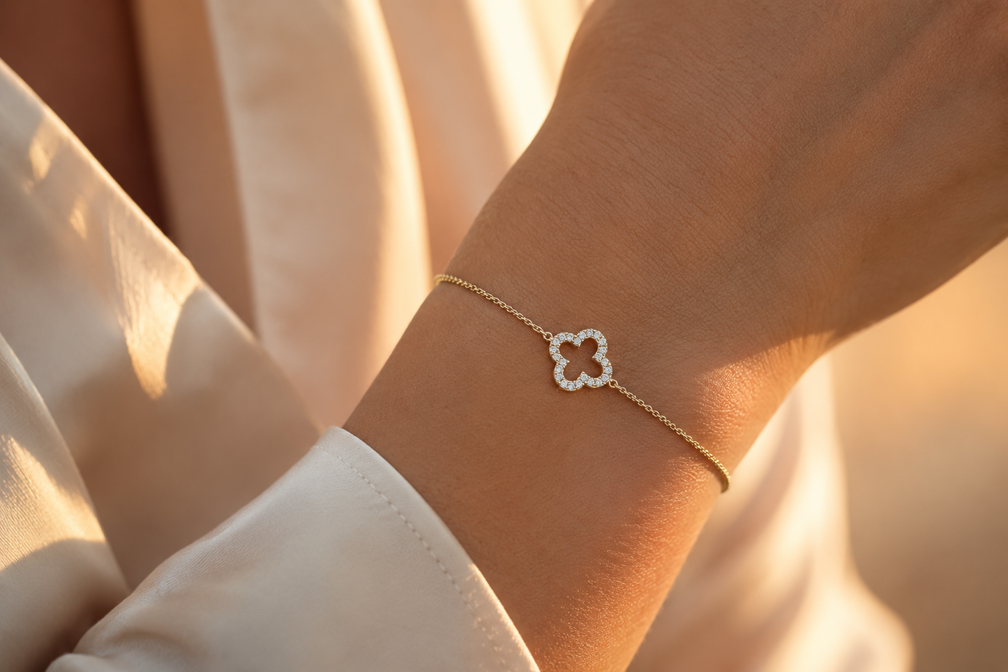 Gros plan sur le poignet d'une femme portant un bracelet trèfle en nacre véritable et or jaune 18 carats, un bijou de peau doux et élégant.