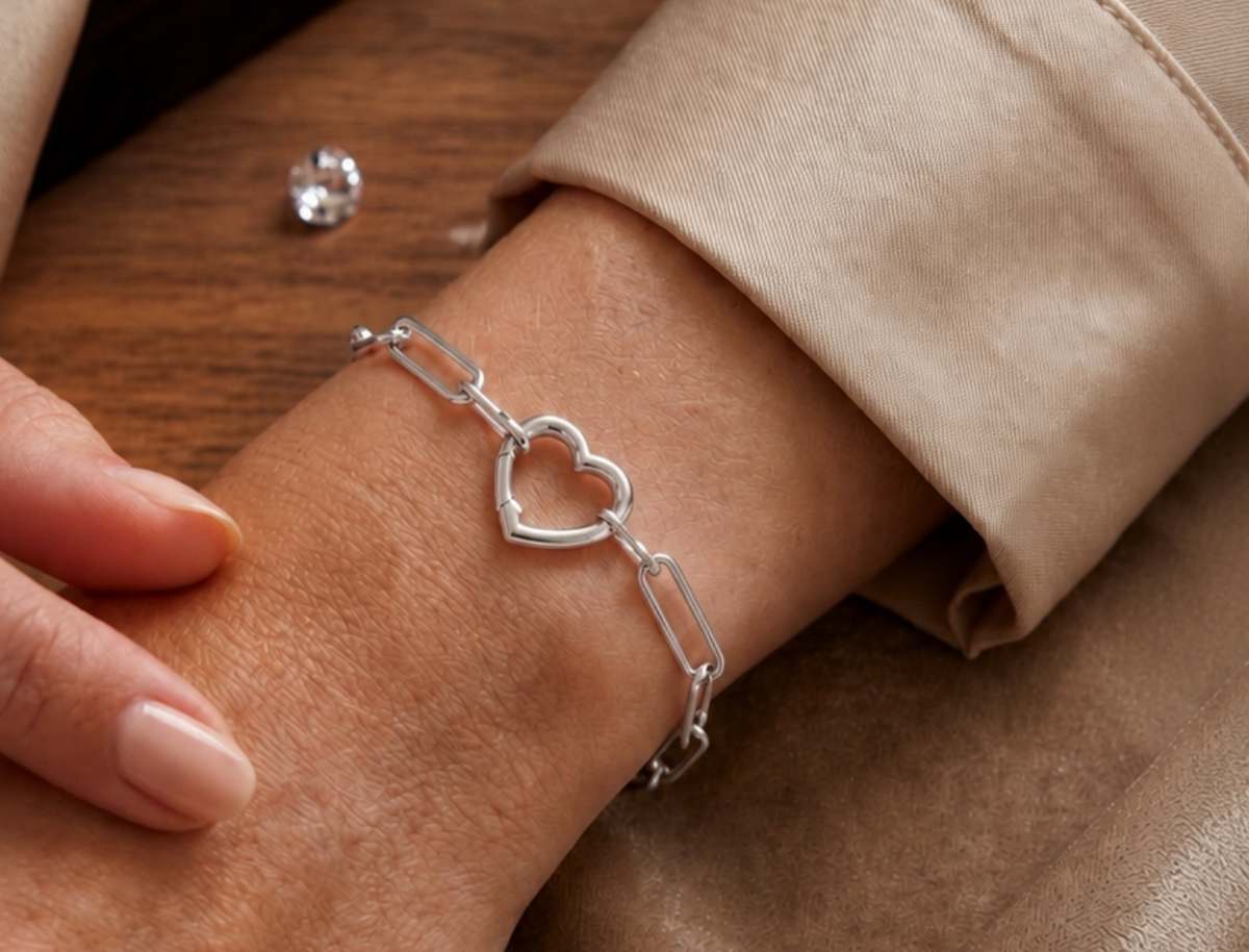 Bracelet trombone en or blanc 18 carats avec fermoir en forme de coeur porté au poignet d'une femme