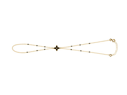 Chaîne de main en or jaune 18 carats avec motif fleur et perles en résine noire, un bijou de main élégant et sobre.