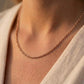 Chaîne de cou maille forçat ronde massive en or rouge (rose) 18 carats portée au cou par une femme