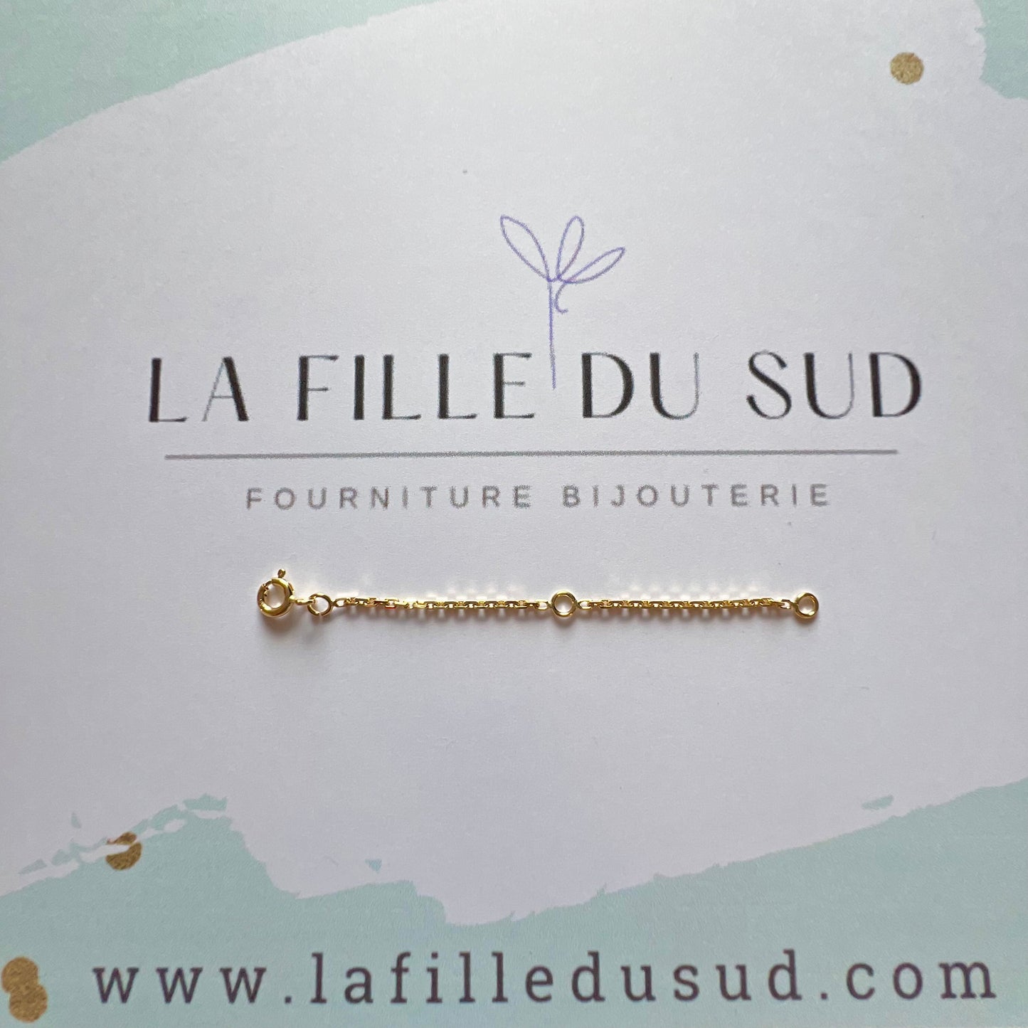 Chaînette de rallonge pour collier ou bracelet en or 18 carats présentée sur la carte de l'atelier de fournitures.