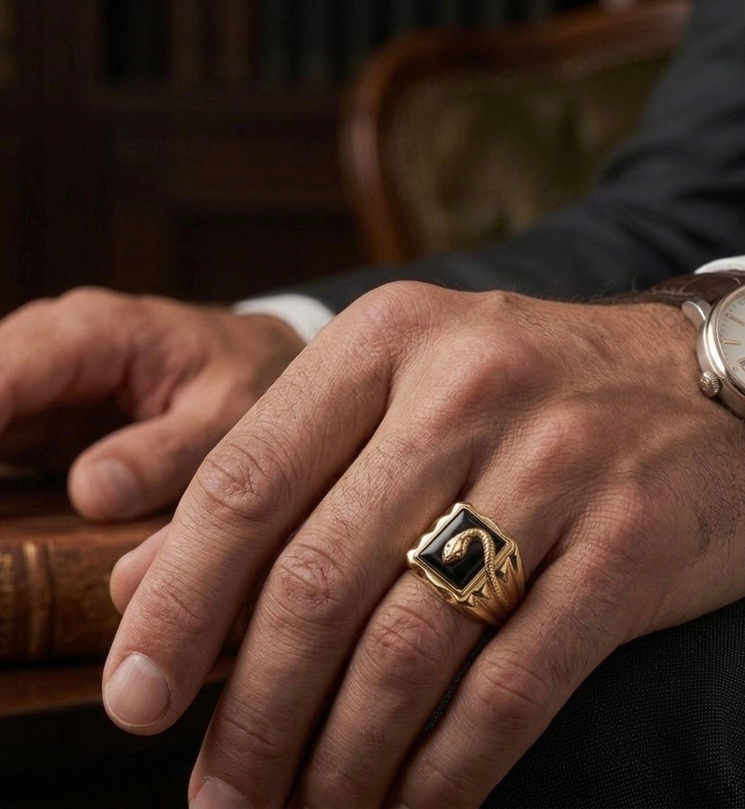Chevalière homme en or jaune 18k avec un serpent sur une pierre onyx noire rectangulaire, portée par un homme