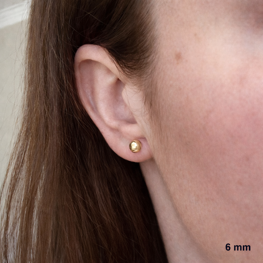 Rendu élégant et discret des clous d'oreilles demi-rond en or 750 au porté.