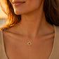 Collier 3 anneaux entrelacés en or jaune 18 carats massif porté par une femme de profil au coucher du soleil.