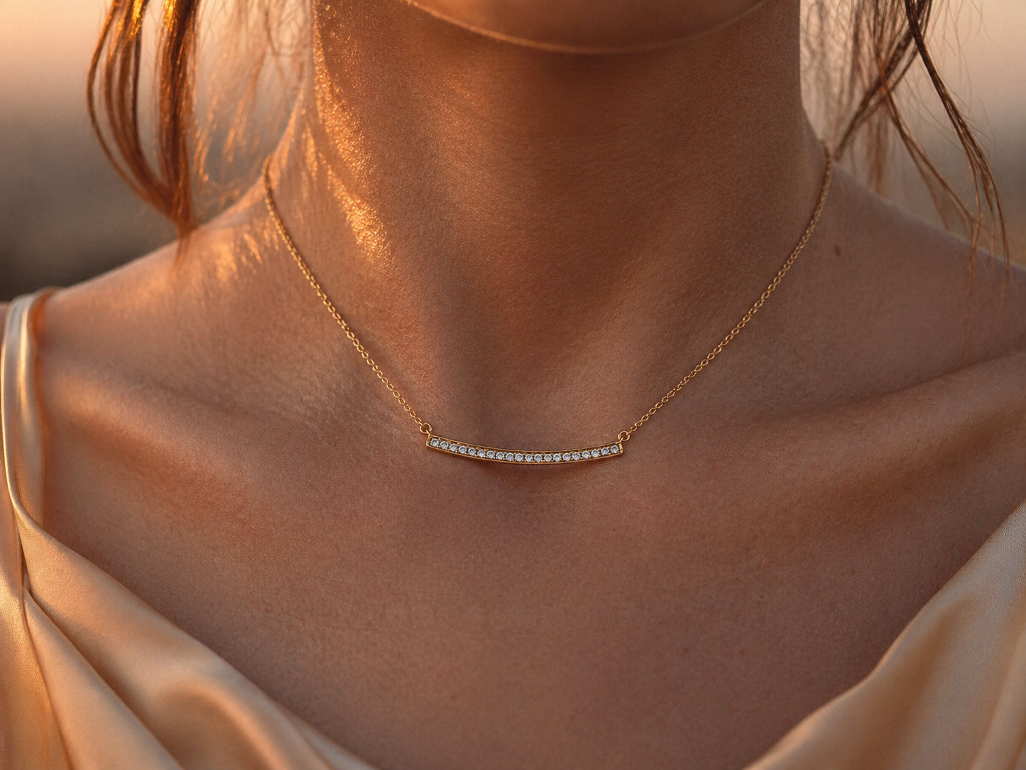 Collier barrette diamant en or jaune 18 carats porté au cou, éclat des diamants naturels sous la lumière du soleil couchant.