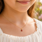Gros plan sur le cou d'une petite fille portant le collier avec pendentif coccinelle en or jaune 18 carats, un bijou porte-bonheur délicat et lumineux.