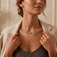 Gros plan sur une femme portant le collier pendentif boule solitaire en or jaune 18 carats, un bijou minimaliste et élégant de l'atelier La Fille du Sud.