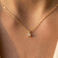 Gros plan sur le décolleté d'une femme portant un collier solitaire en or jaune 18 carats serti d'un diamant naturel de 0,15 carat.