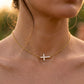 Collier ras-de-cou en or jaune 18 carats avec une croix horizontale sertie de diamants naturels, porté par une femme.