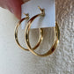 Détail technique de l'arrière et de la charnière pivotante des boucles d'oreilles créoles épaisses en or jaune 18 carats.
