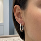 Créole ovale en or blanc non rhodié 18 carats portée au lobe d'une femme.