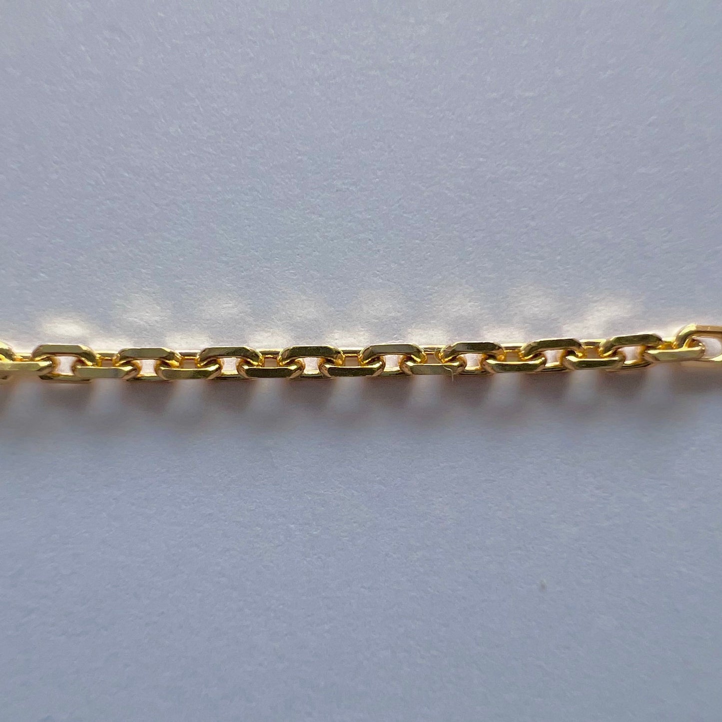 Zoom sur la structure et la brillance de la maille forçat diamantée de 1,47 mm en or jaune massif.