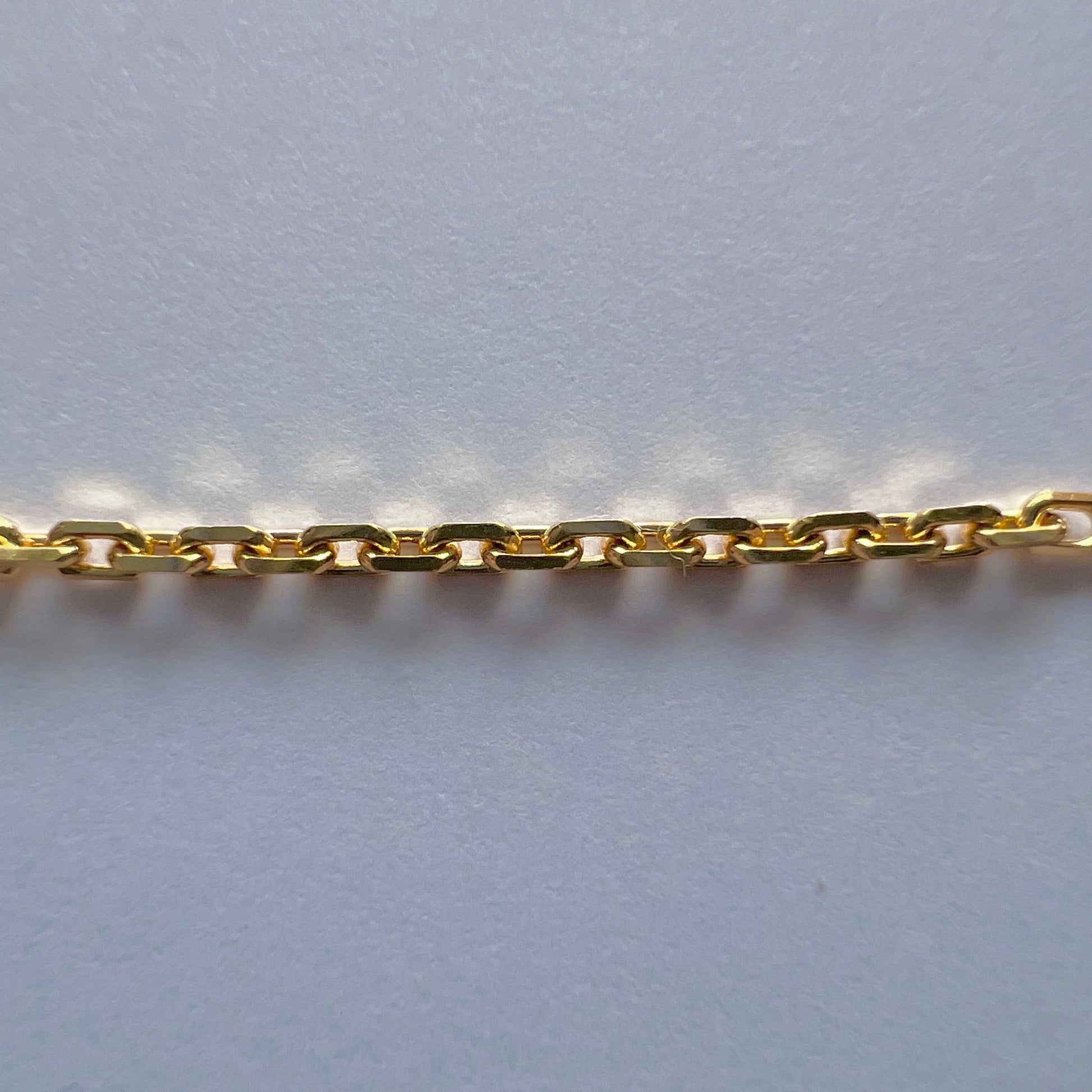 Zoom sur la structure et la brillance de la maille forçat diamantée de 1,47 mm en or jaune massif.