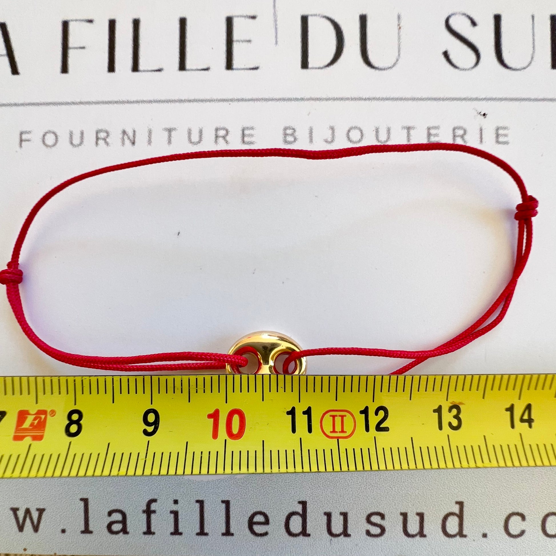 Bracelet cordon rouge porte-bonheur avec un graine de café en or 18 carats.