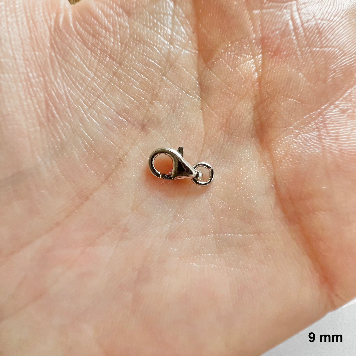 fermoir mousqueton or blanc avec son anneau ouvert prêt à monter.