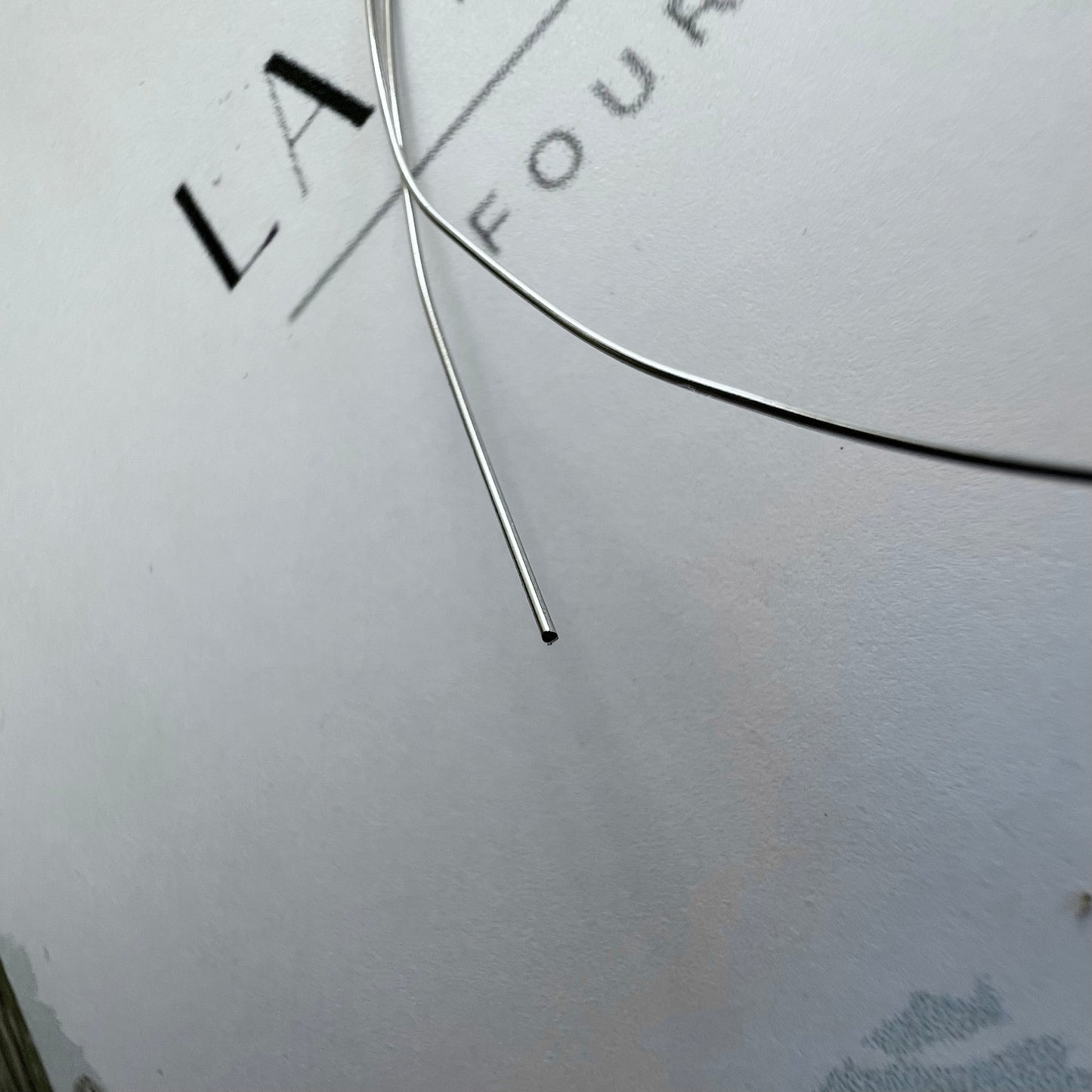 Finesse du fil d'or gris massif 18 carats pour montage de bijoux, diamètre d'un demi-millimètre.