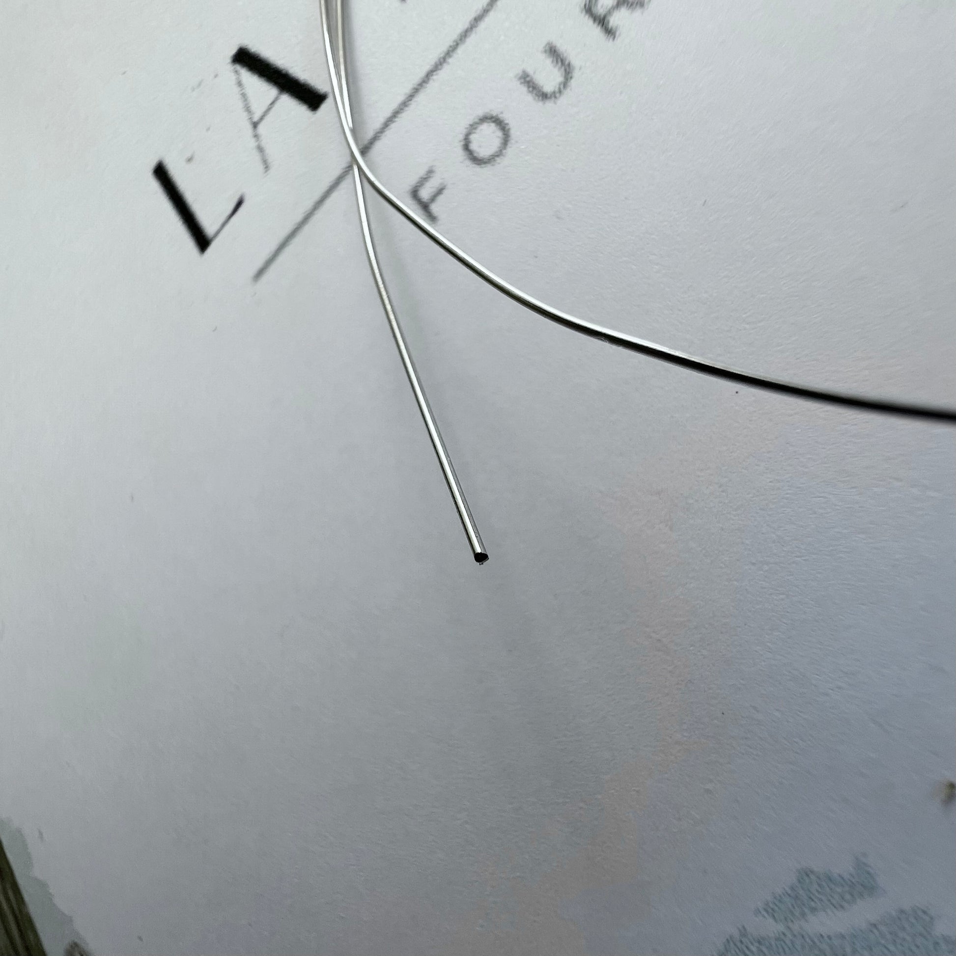 Finesse du fil d'or gris massif 18 carats pour montage de bijoux, diamètre d'un demi-millimètre.