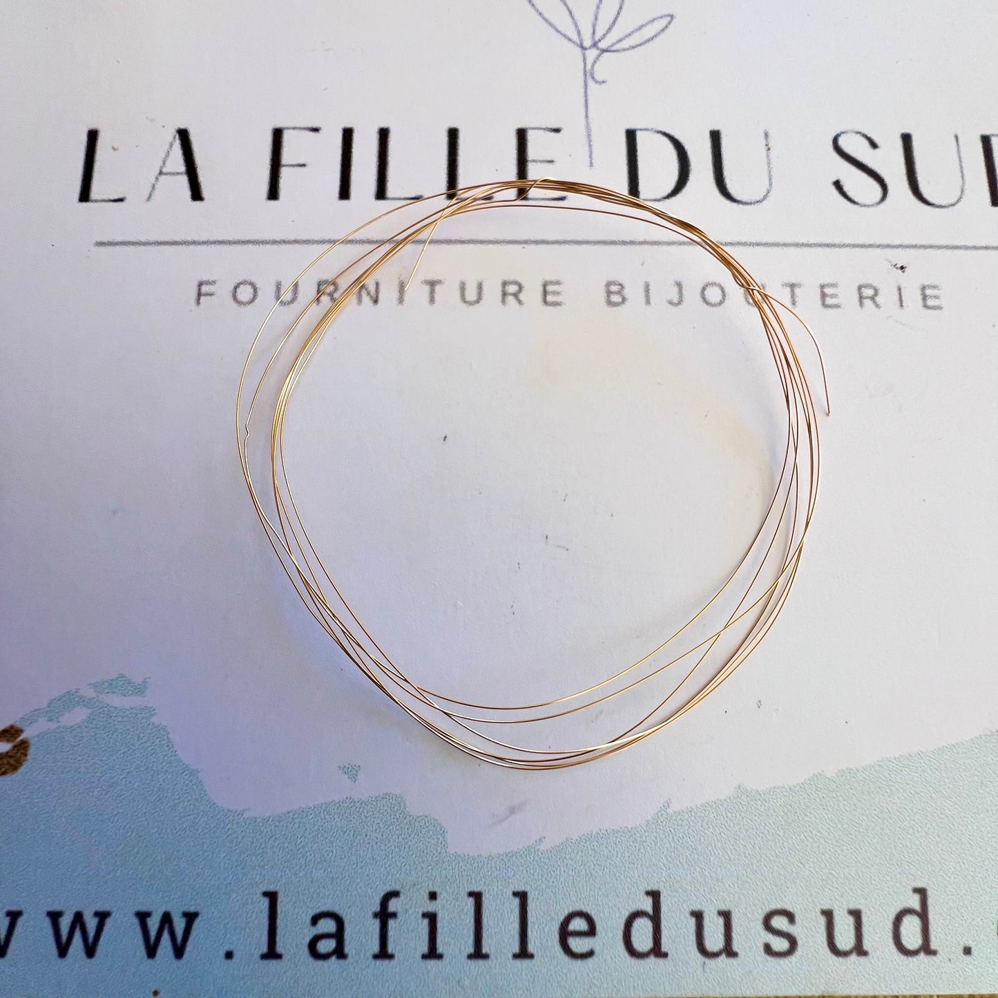 Fil rond en or rose 18 carats massif de 0,20mm présenté sur la carte de l'atelier La Fille du Sud.